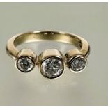 A 9ct gold diamond three stone graduated ring, the center stone approximately 0.28ct collette set