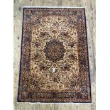 A Persian style rug, the ivory field decorated with floral medallion and conforming spandrels, the