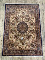 A Persian style rug, the ivory field decorated with floral medallion and conforming spandrels, the