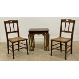 A pair of Edwardian walnut bedroom chairs, with spindle back rest and cane seats, raised on turned