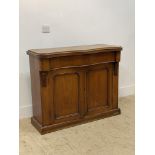 A Victorian mahogany side cabinet of serpentine outline, fitted with a frieze drawer, above two