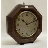 An early 20th century single train wall clock in an octagonal oak case, the silvered dial with