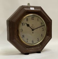 An early 20th century single train wall clock in an octagonal oak case, the silvered dial with