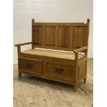 A pine hall bench, late 20th century, with four panel back over open arms and two drawers to base,