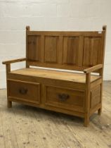 A pine hall bench, late 20th century, with four panel back over open arms and two drawers to base,
