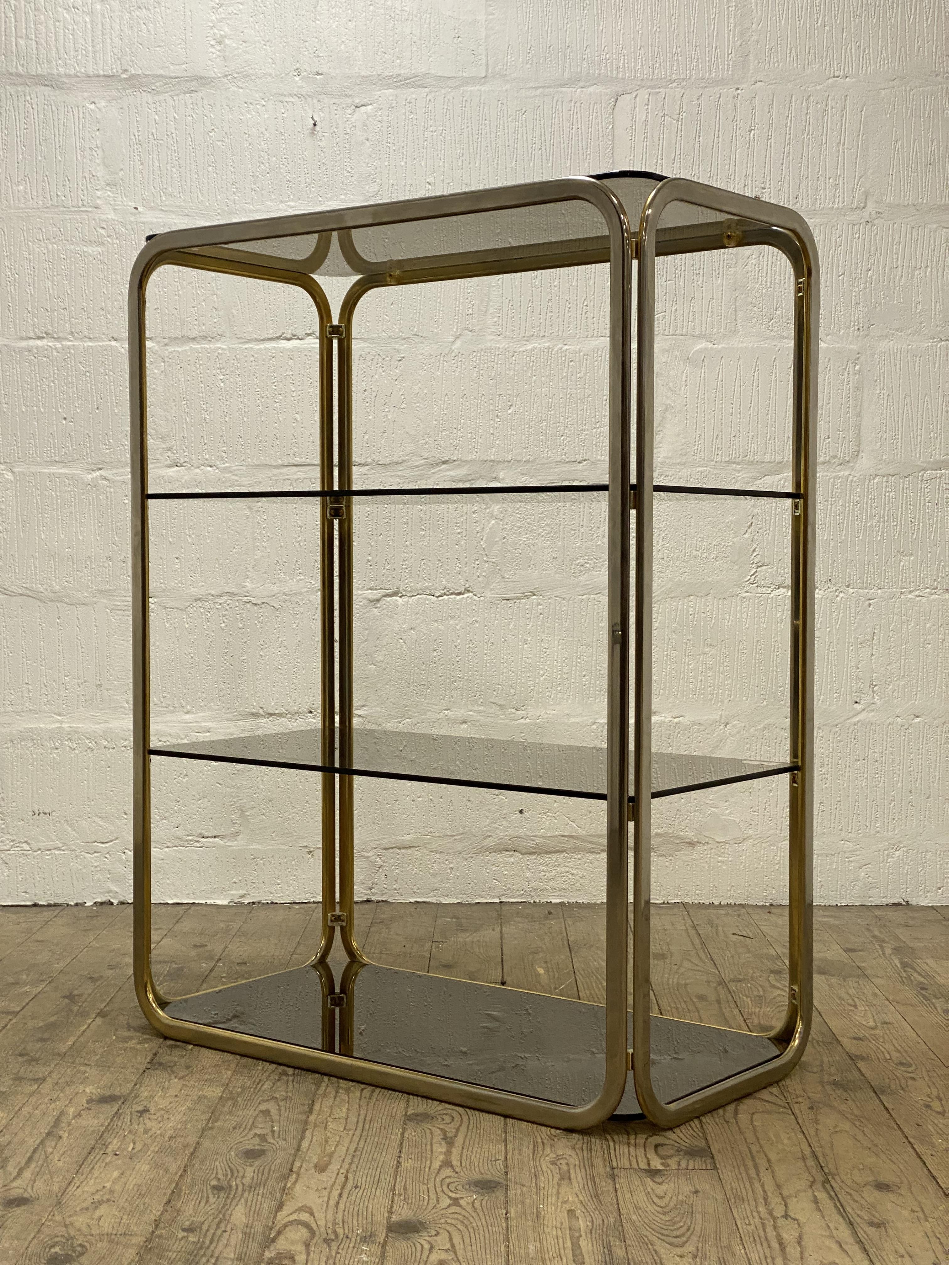 A Vintage 1980's four height gilt metal and smoked glass etagere. H108cm, W88cm, D43cm.