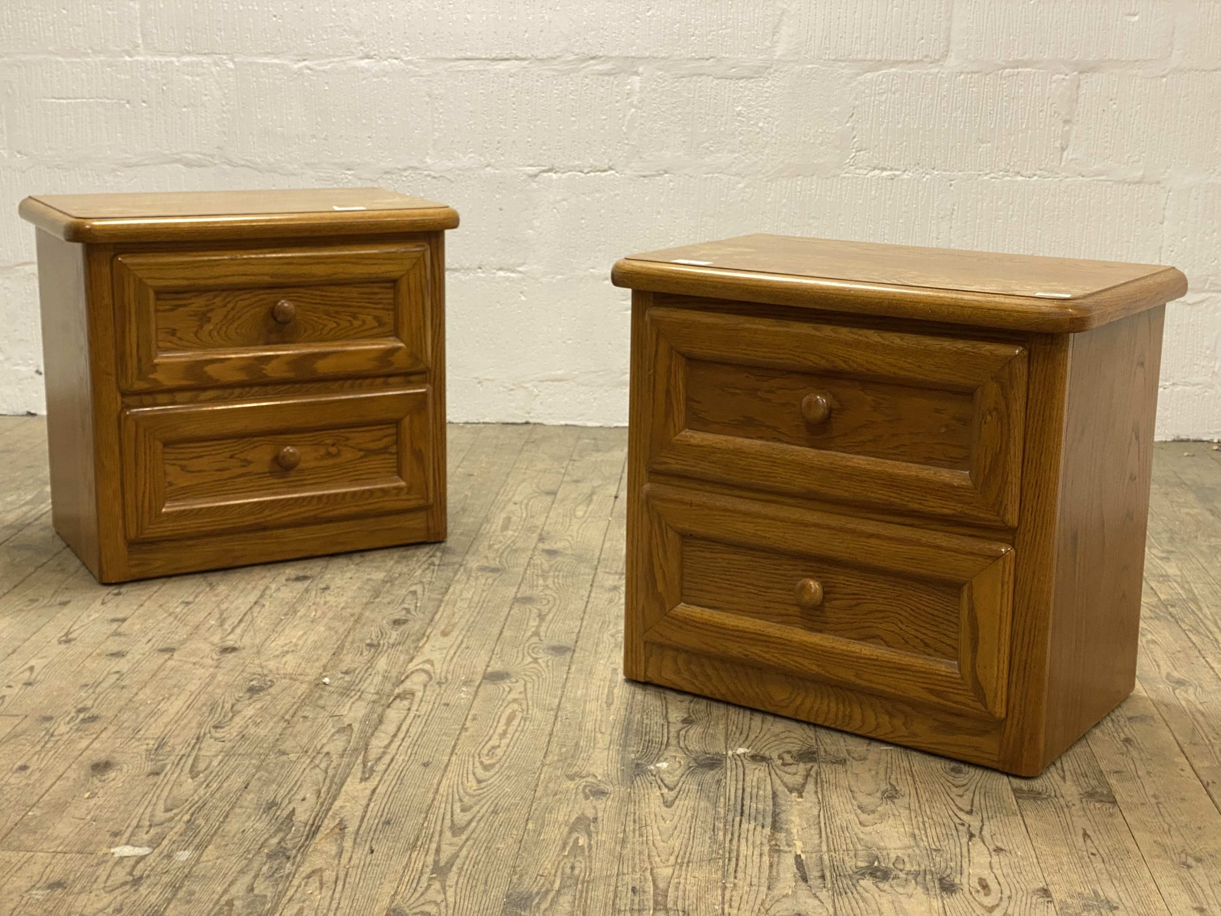 A pair of Canadian oak two drawer bedside chests. H60cm, W65cm, D40cm .