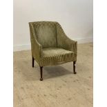 An early 20th century upholstered easy chair, raised on turned front supports with pad feet. H80cm.