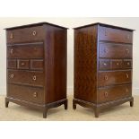 A pair of Stag minstrel chests, each fitted with four long and three short drawers, raised on