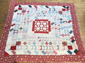 A 1930s-40s square patchwork cotton comfy quilt with chevron, diamond repeating rows to central