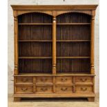 An Indonesian hardwood bookcase cabinet, the projecting cornice above two arched niches, each fitted