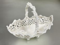 A Edwardian Coalport china blanc de chine oval pierced floral art basket with rustic handle raised