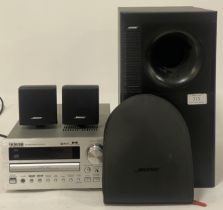 A Bose Acoustimass audio system, comprising a subwoofer and two cube satellite speakers (3) together