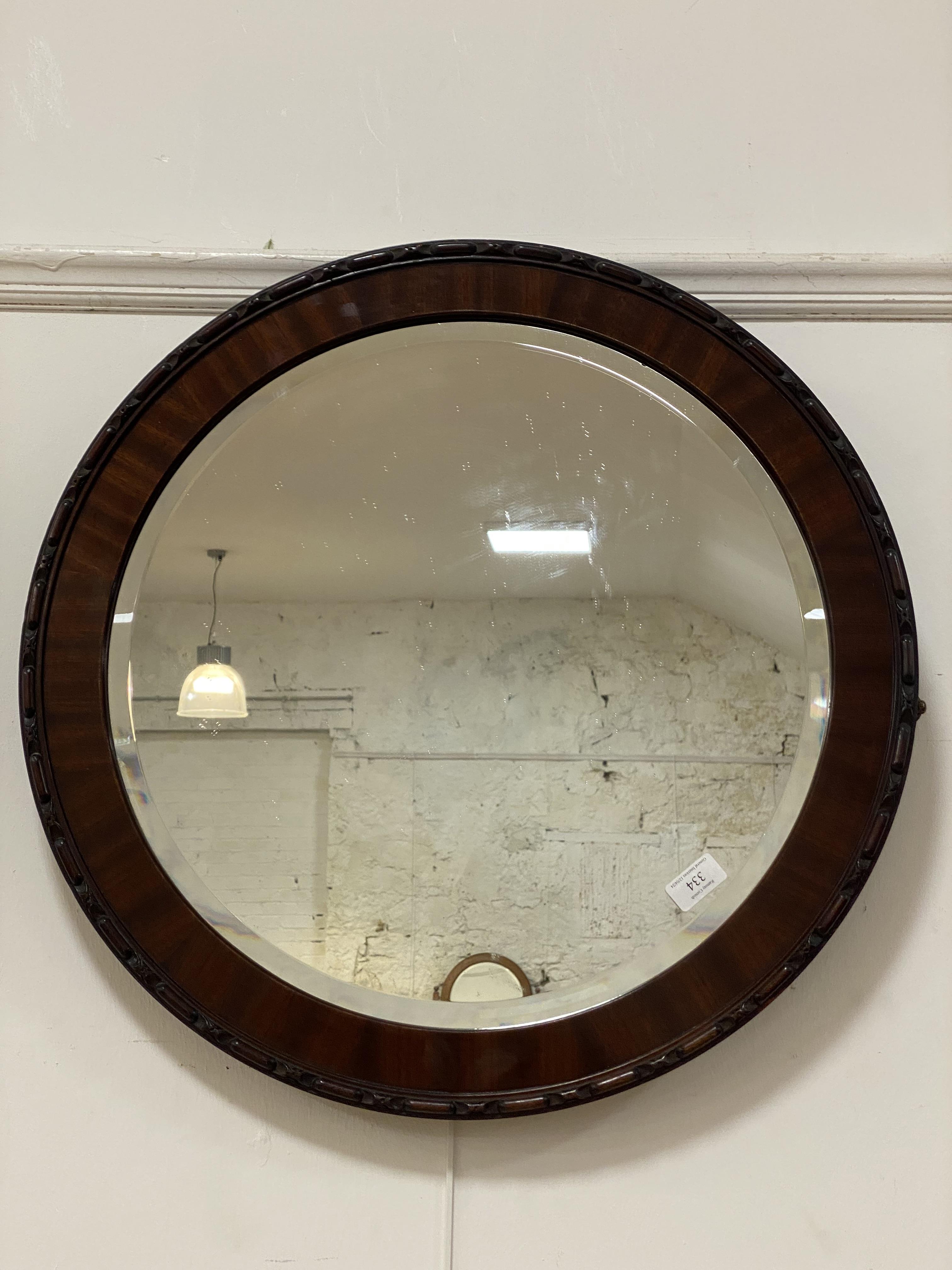 A 20th century mahogany framed circular wall mirror with bevelled glass. D62cm