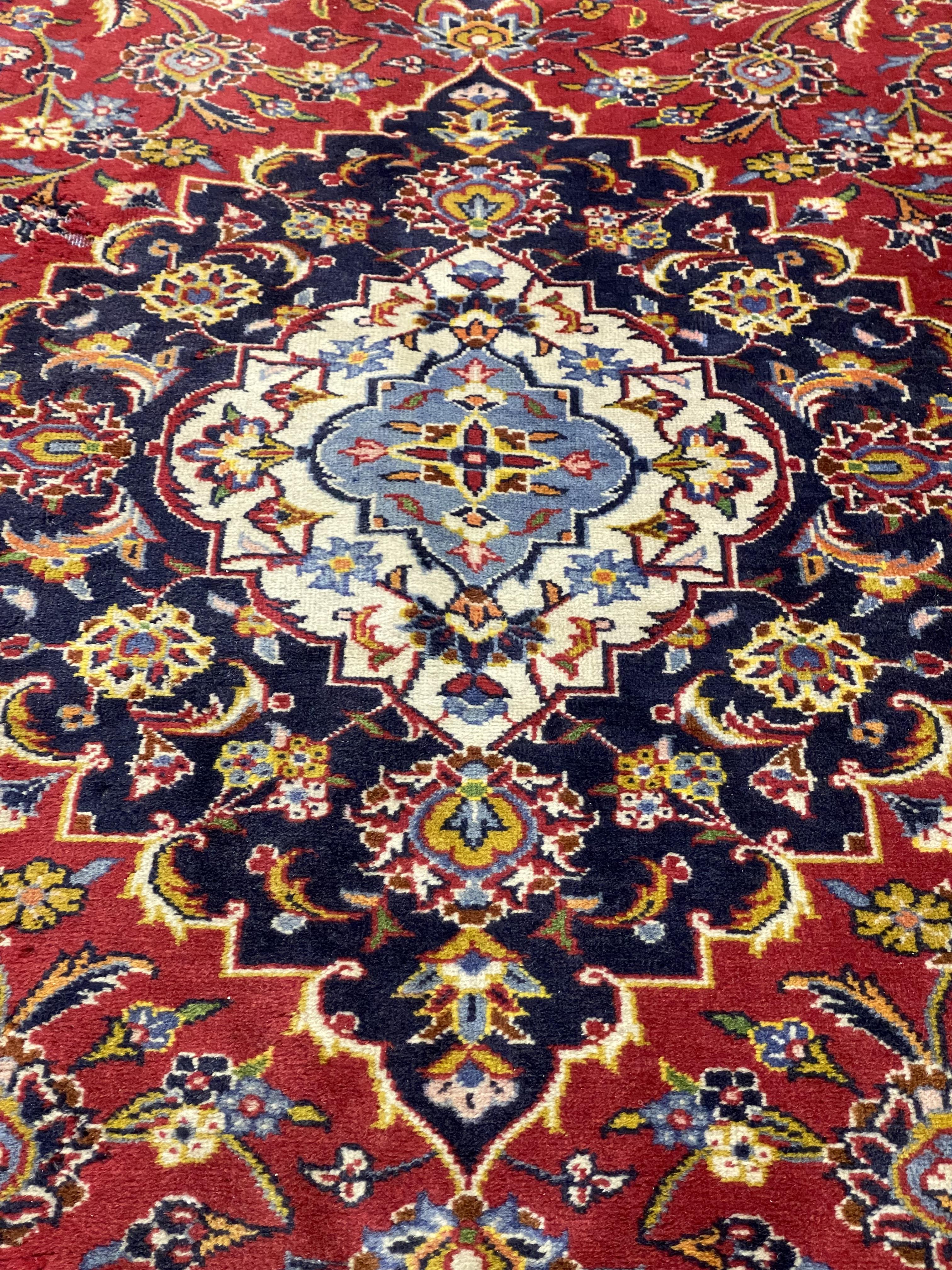 A hand knotted Persian Keshan rug, the red field centred with medallion and enclosed by conforming - Image 2 of 2