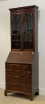 A George III mahogany bureau bookcase, the dentil cornice above two tracery glazed doors enclosing