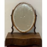 An early 19th century inlaid mahogany toilet mirror, with oval bevelled plate above a serpentine