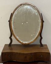 An early 19th century inlaid mahogany toilet mirror, with oval bevelled plate above a serpentine
