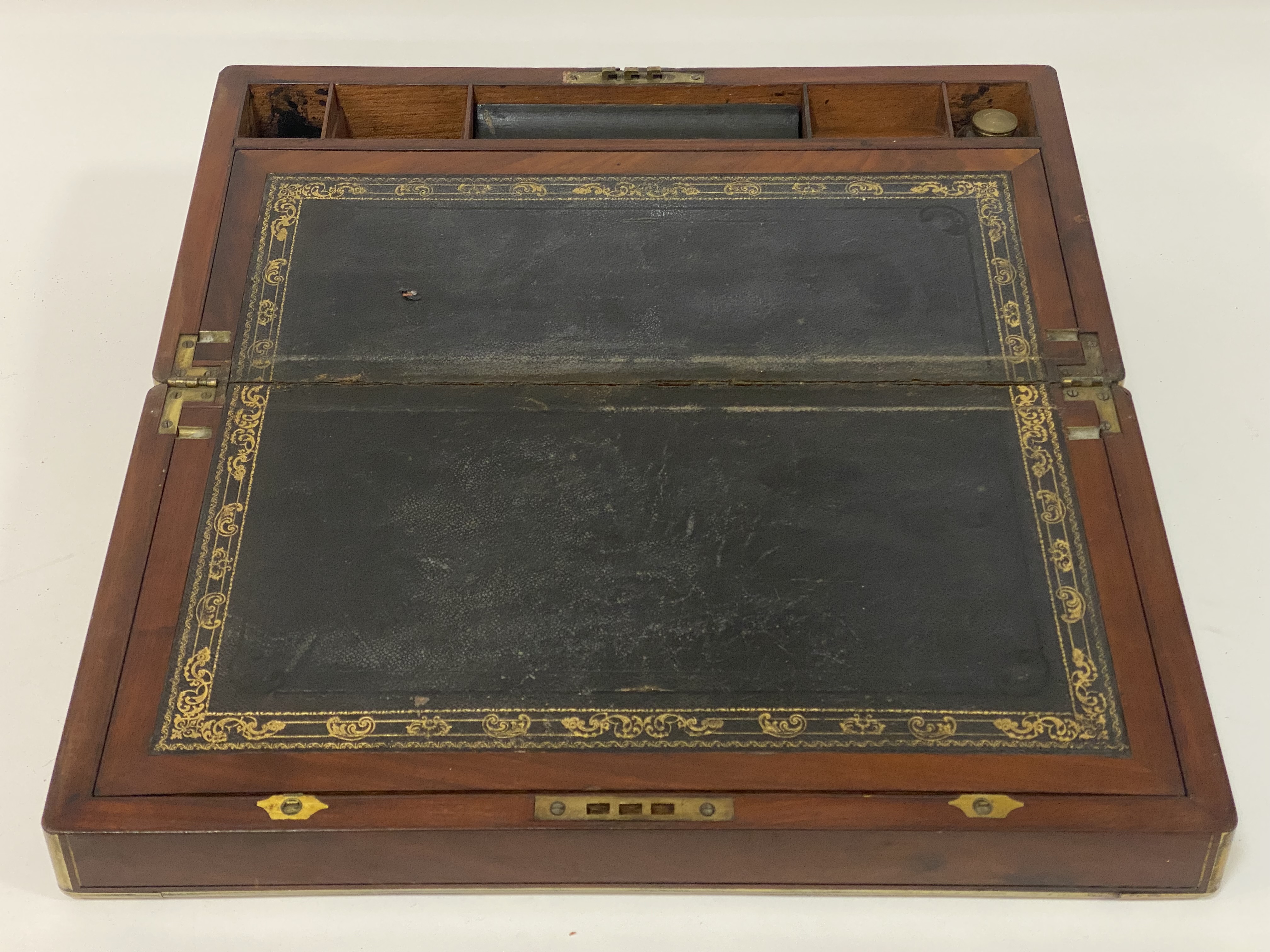 A 19th century mahogany brass bound writing slope, having a fitted interior and inset with gilt