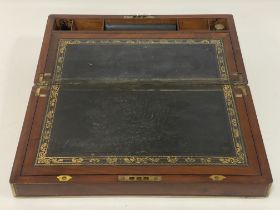 A 19th century mahogany brass bound writing slope, having a fitted interior and inset with gilt