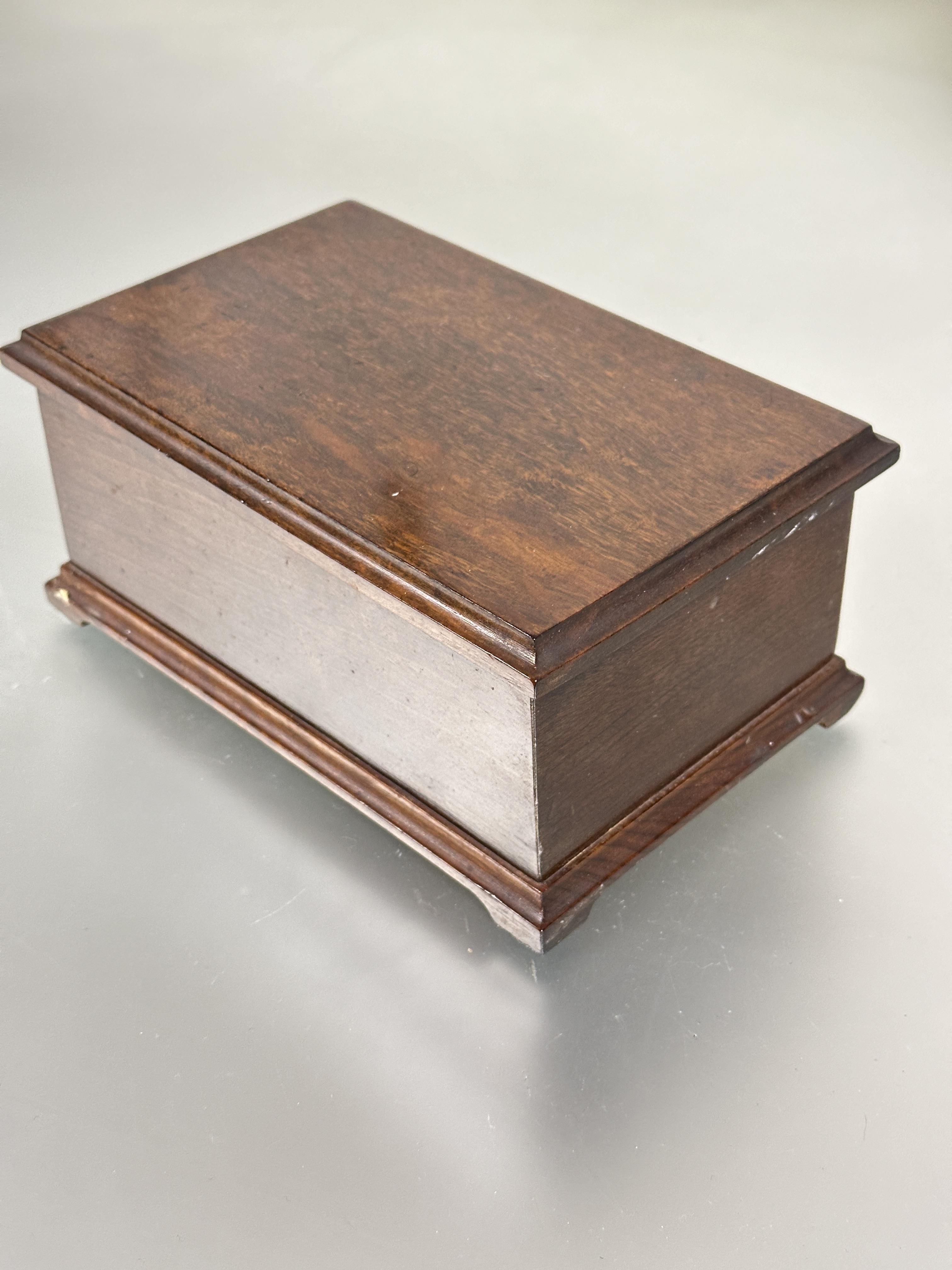 A 1920s hand made walnut cigarette box, the hinged top enclosing a rise and fall dispenser for forty