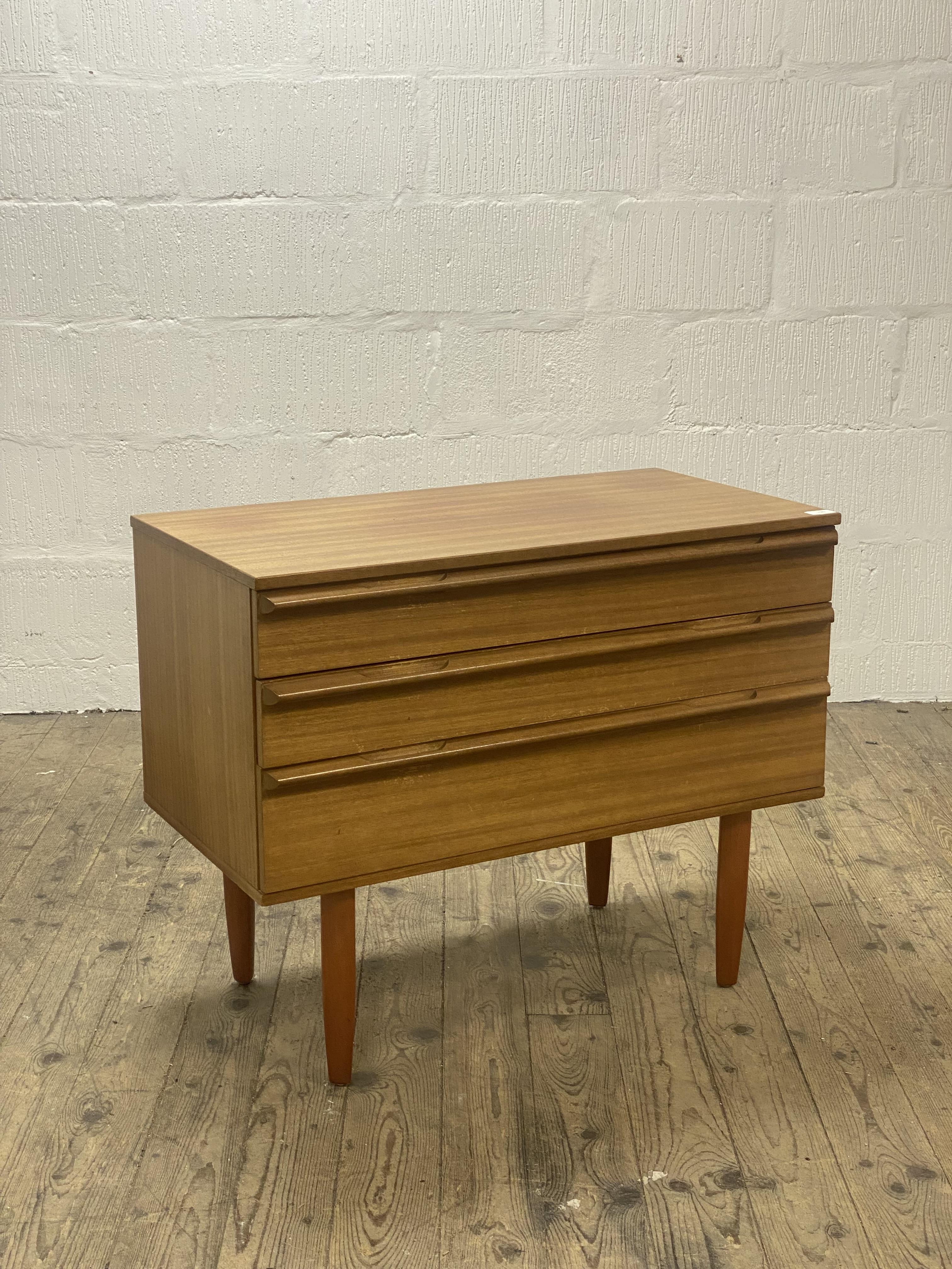 A mid century teak chest, fitted with three drawers and standing on turned and tapered supports. - Image 2 of 2