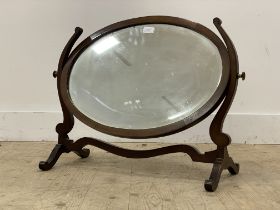 An Edwardian mahogany framed oval vanity mirror with bevelled plate. H54cm,.