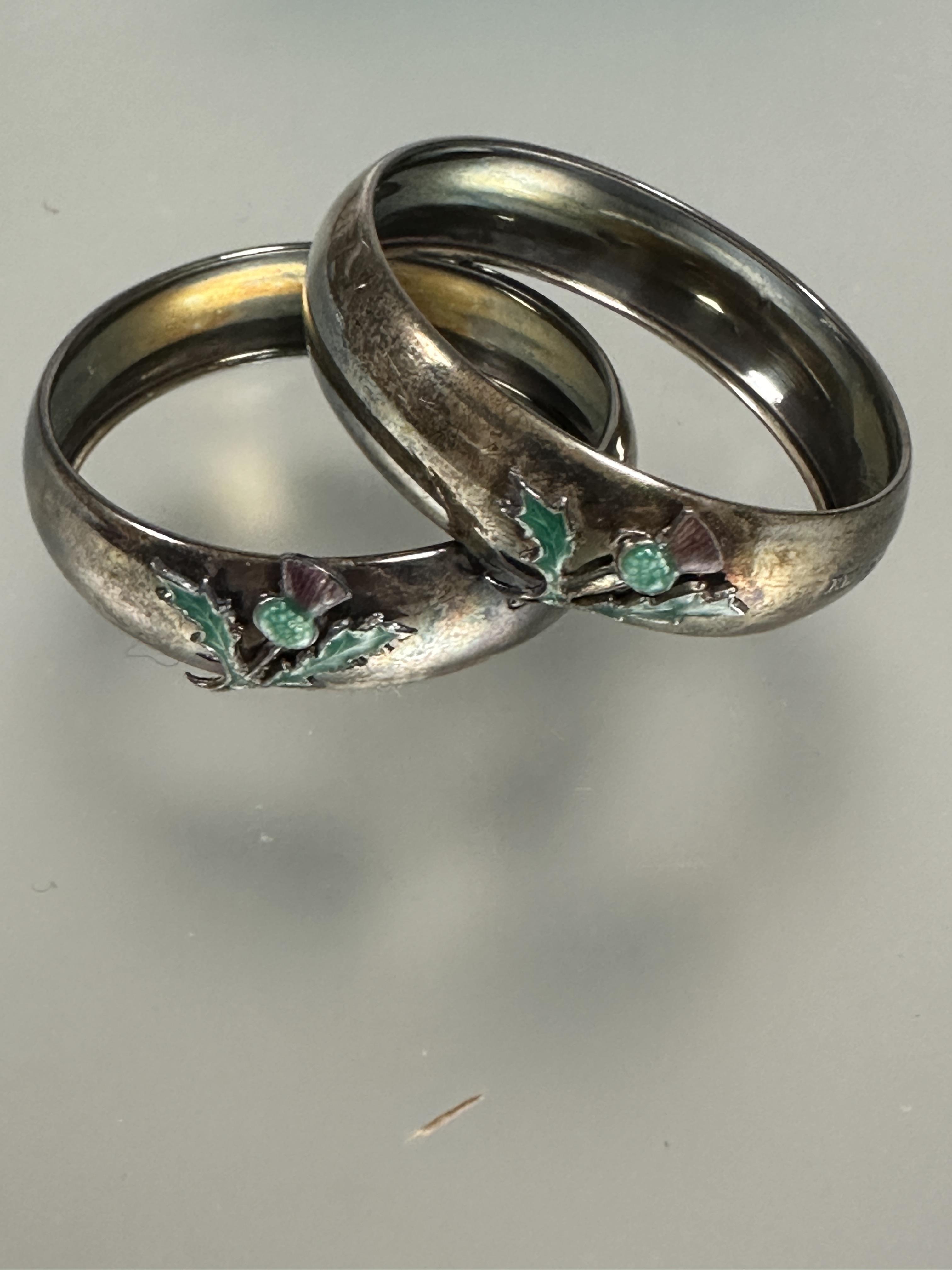 A pair of Edwardian Birmingham silver circular napkin rings mounted with enamel Scottish thistles no - Image 2 of 4