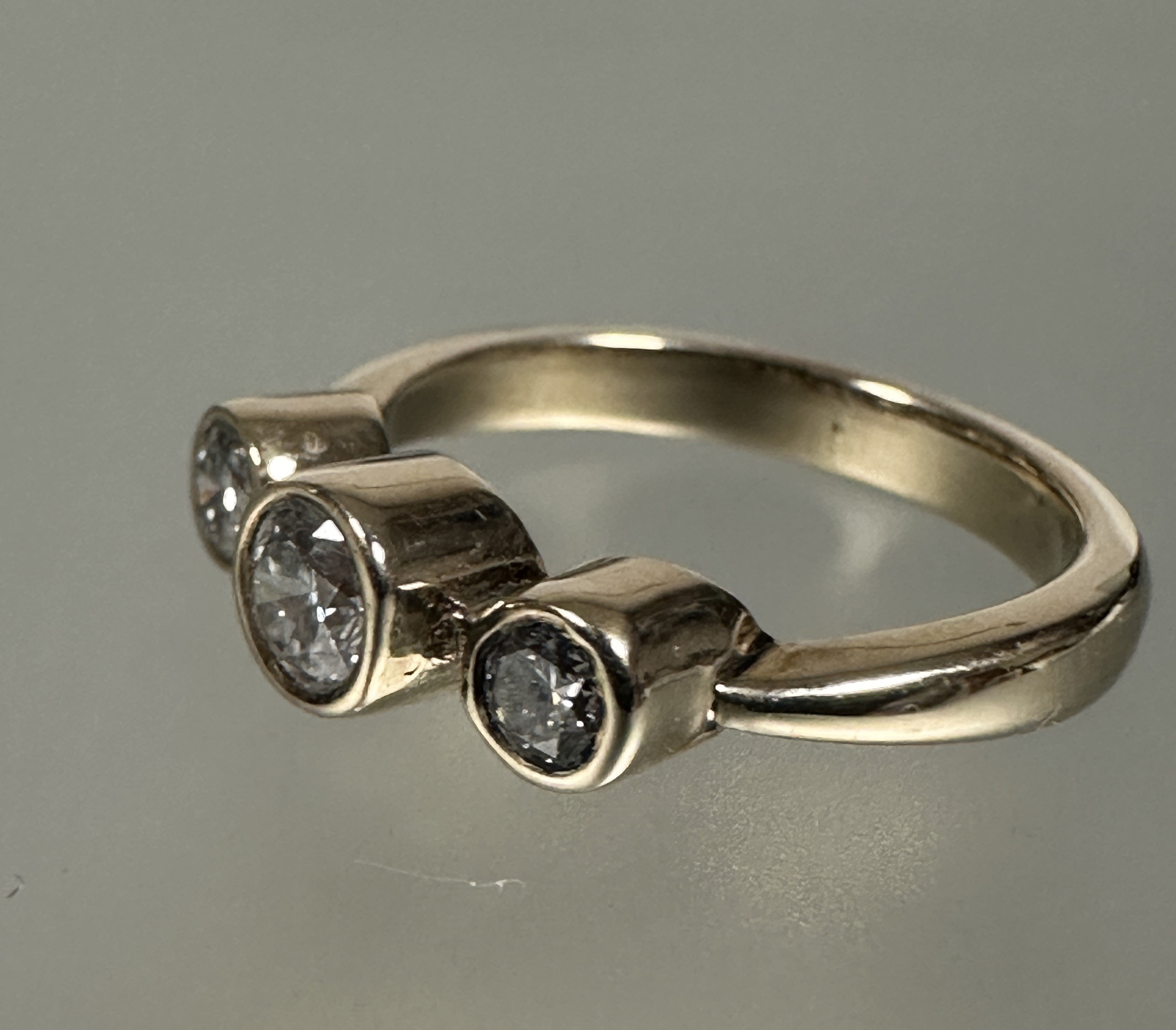 A 9ct gold diamond three stone graduated ring, the center stone approximately 0.28ct collette set - Image 2 of 4