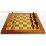 A large birch and walnut veneered chessboard (50cm X 50cm), together with pieces (missing one pawn)