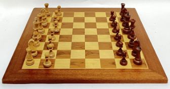 A large birch and walnut veneered chessboard (50cm X 50cm), together with pieces (missing one pawn)