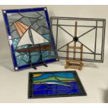 A group of three lead glazed and stained glass panels. largest 59cm x 58cm.