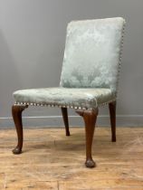 A George II walnut side chair, mid 18th century, the square back and seat upholstered in a blue /