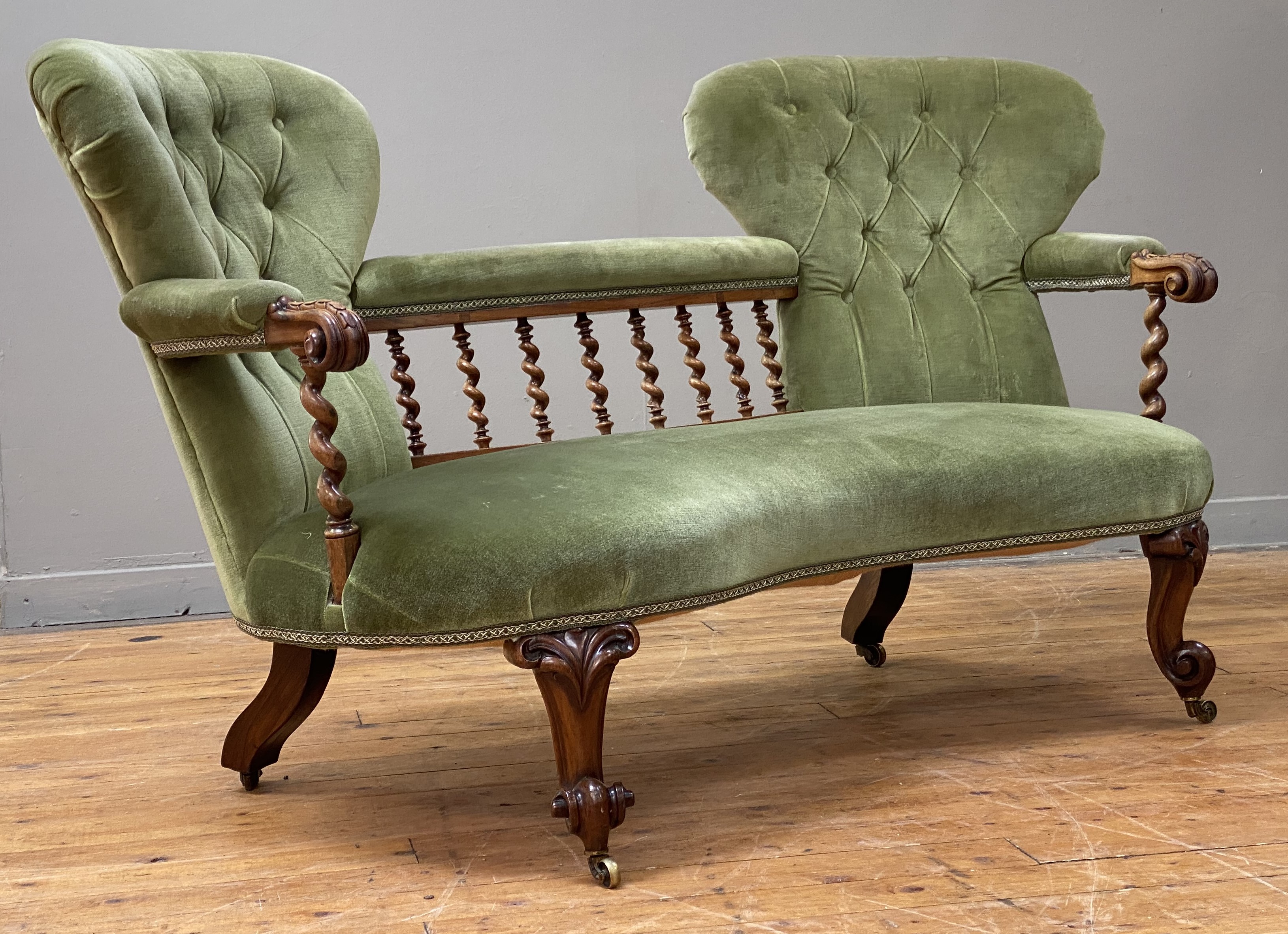 A Victorian rosewood salon settee, the twin spoon back, united by a spiral turned gallery and