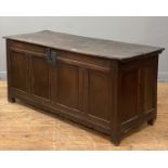 An English oak coffer of pegged and jointed construction, 17th century, the hinged lid opening on