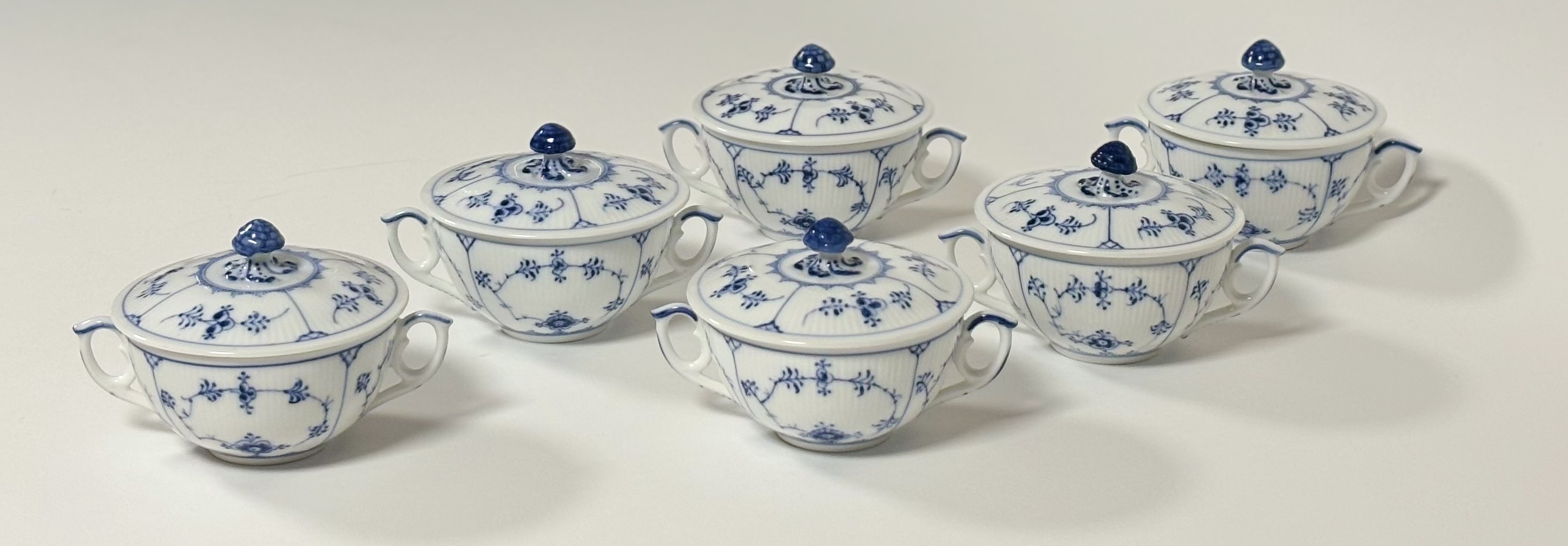 A set of six Royal Copenhagen soup cups and covers in the plain fluted blue pattern (Musselmalet),