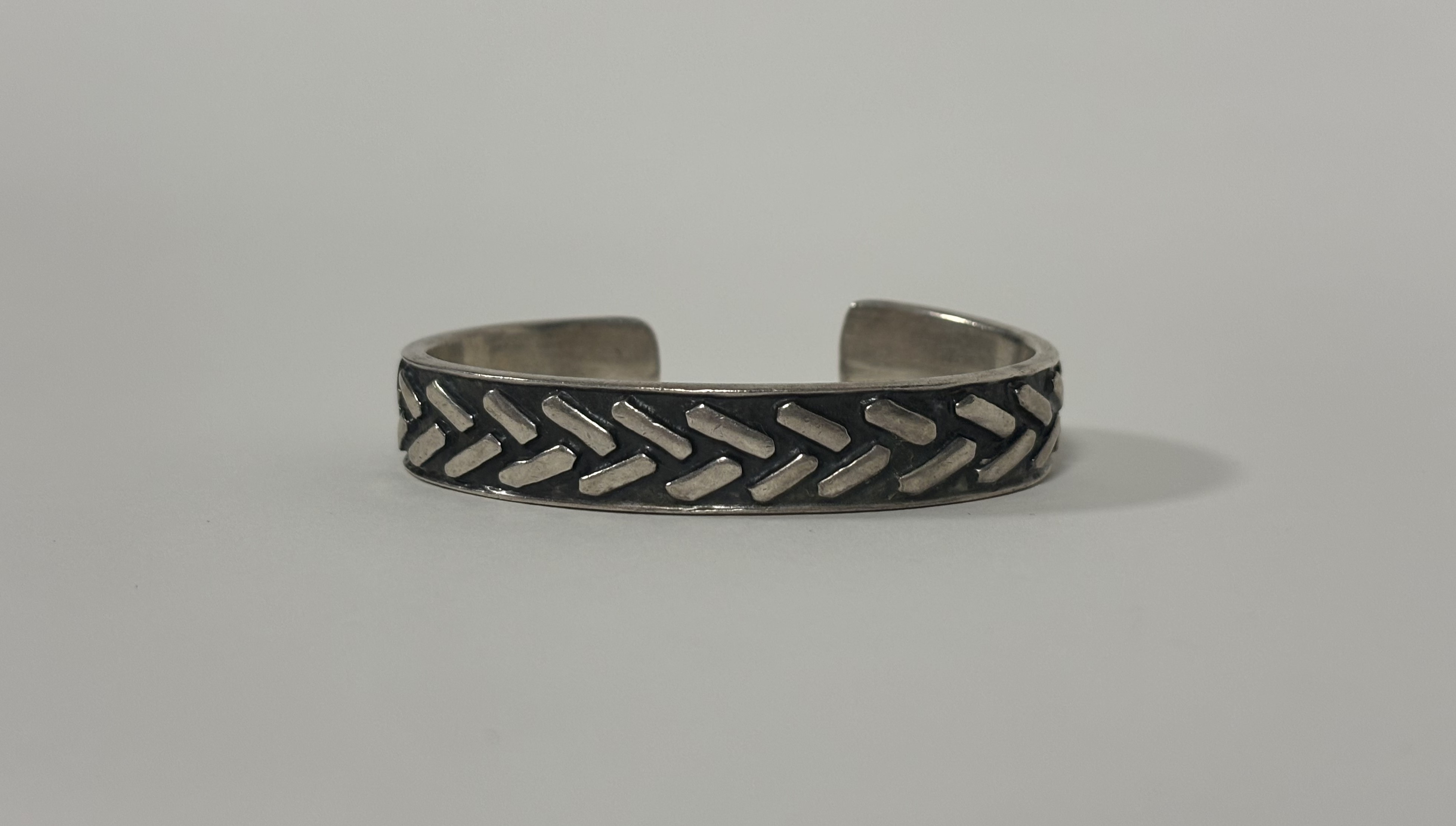 Patrick Mavros, a sterling silver bangle, repousse with a chevron pattern against a blackened