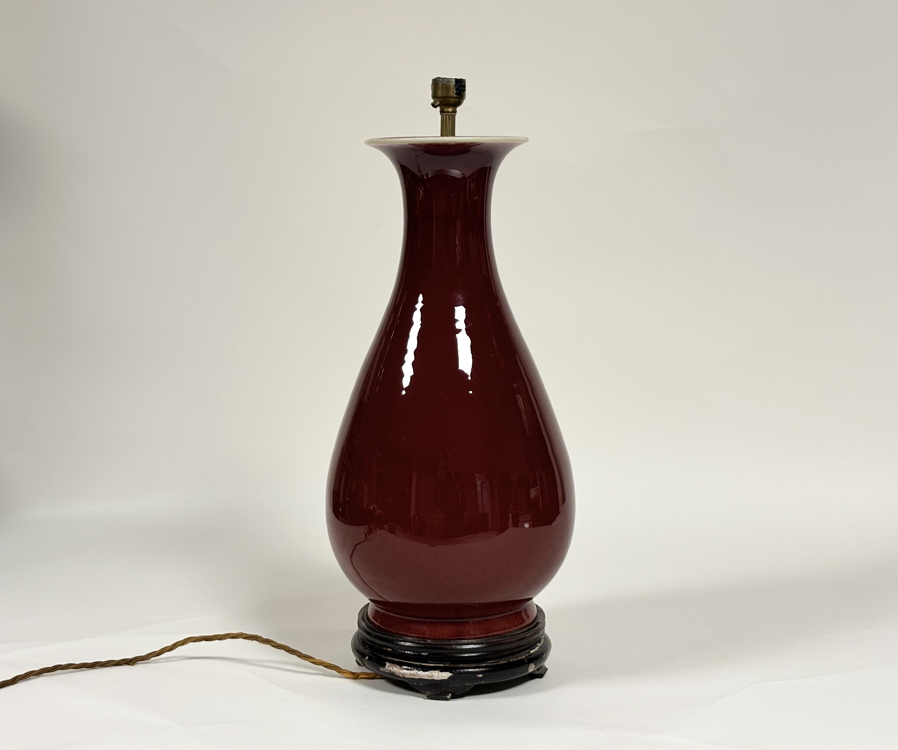 A Chinese porcelain vase in an oxblood glaze, of baluster form, mounted as a table lamp, on an