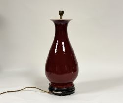 A Chinese porcelain vase in an oxblood glaze, of baluster form, mounted as a table lamp, on an