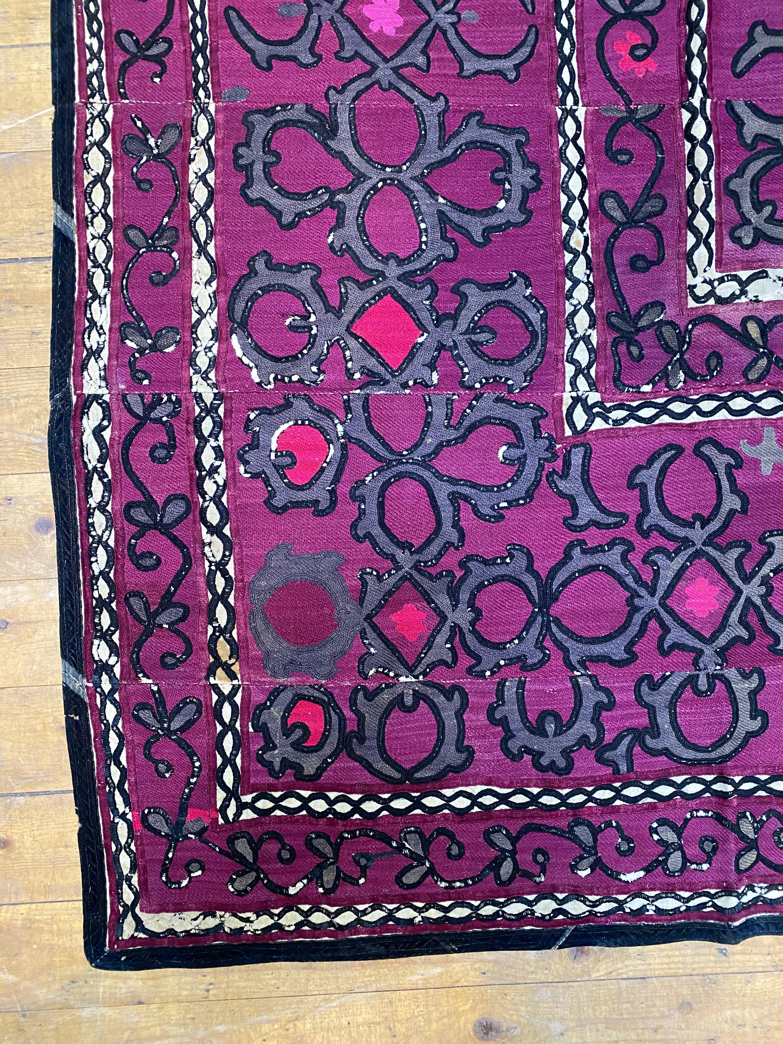 A large Turkoman Suzani wall hanging, circa 1900, the purple ground embroidered with interlaced - Image 3 of 4