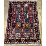 A hand knotted Persian style garden rug, the red field decorated with multiple panels depicting