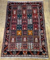 A hand knotted Persian style garden rug, the red field decorated with multiple panels depicting