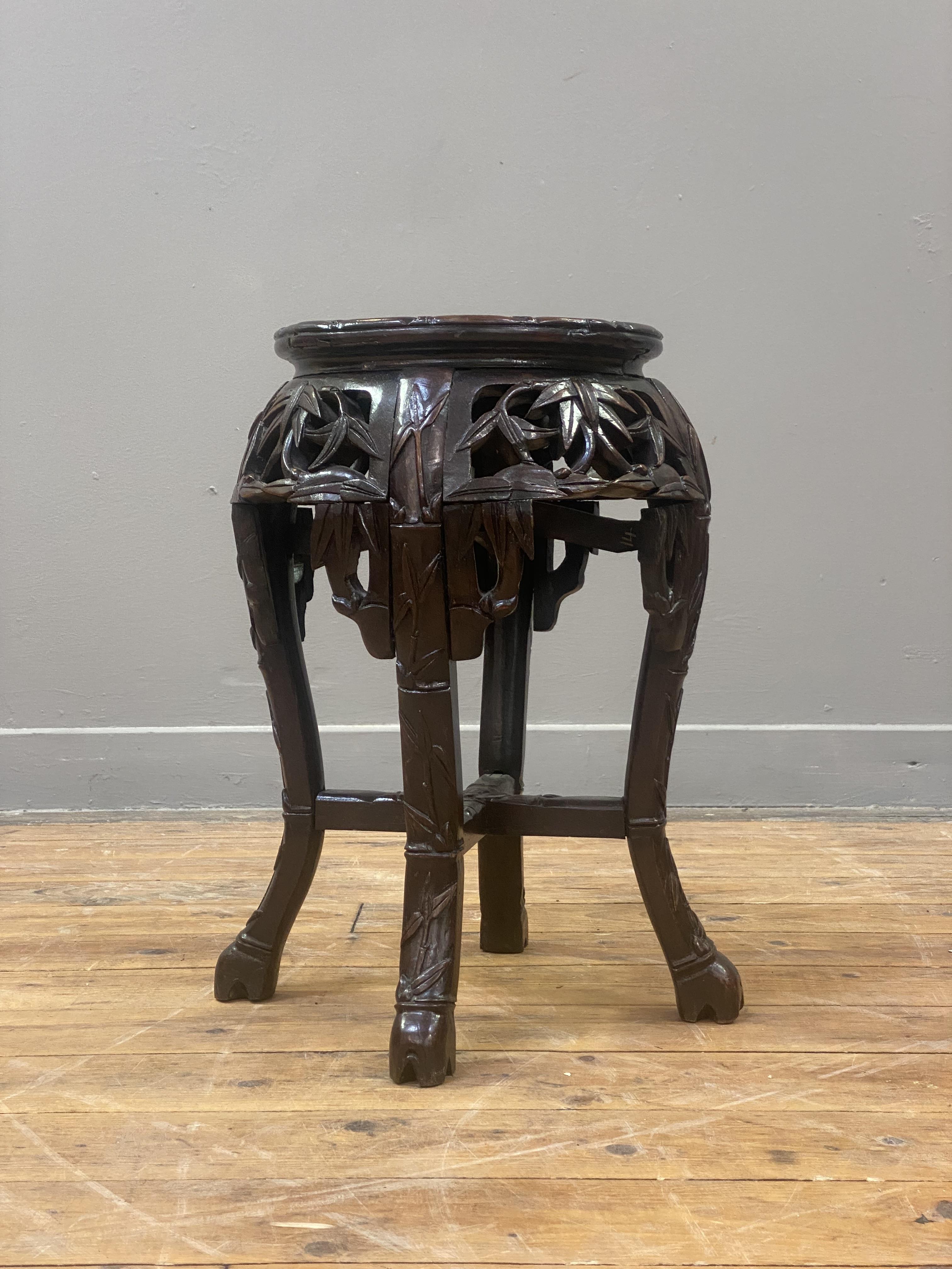 A late Qing dynasty Chinese stained hardwood jardinière stand, the circular top inset with rouge