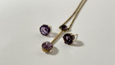 An Edwardian 9ct gold amethyst bar pendant the oval-cut amethyst claw-set and suspended from a