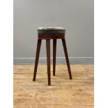 An early 19th century mahogany high stool, the seat upholstered in embroidered fabric worked in a