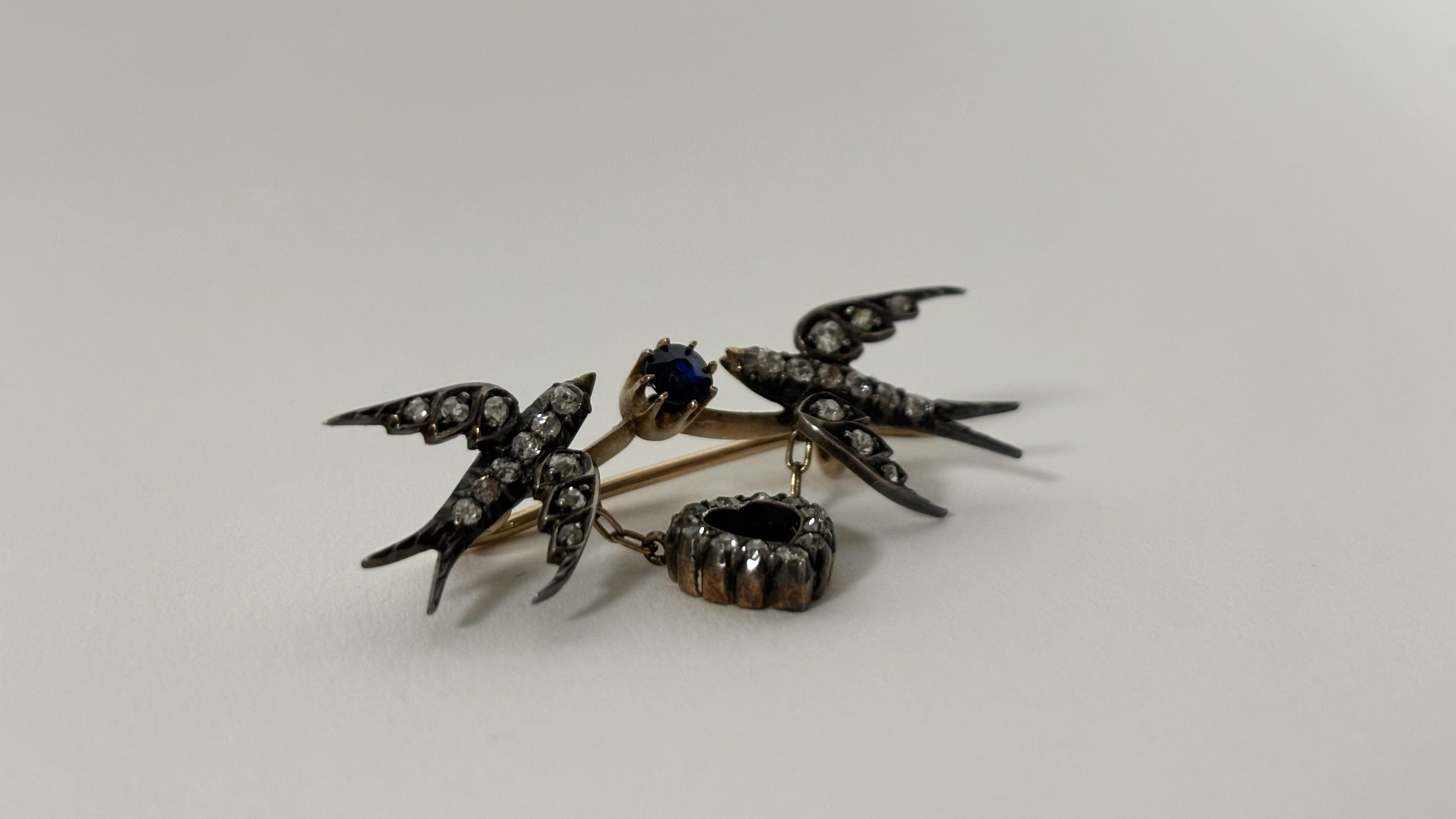 A late Victorian diamond and sapphire brooch modelled as a pair of swallows suspending a heart, - Image 3 of 3