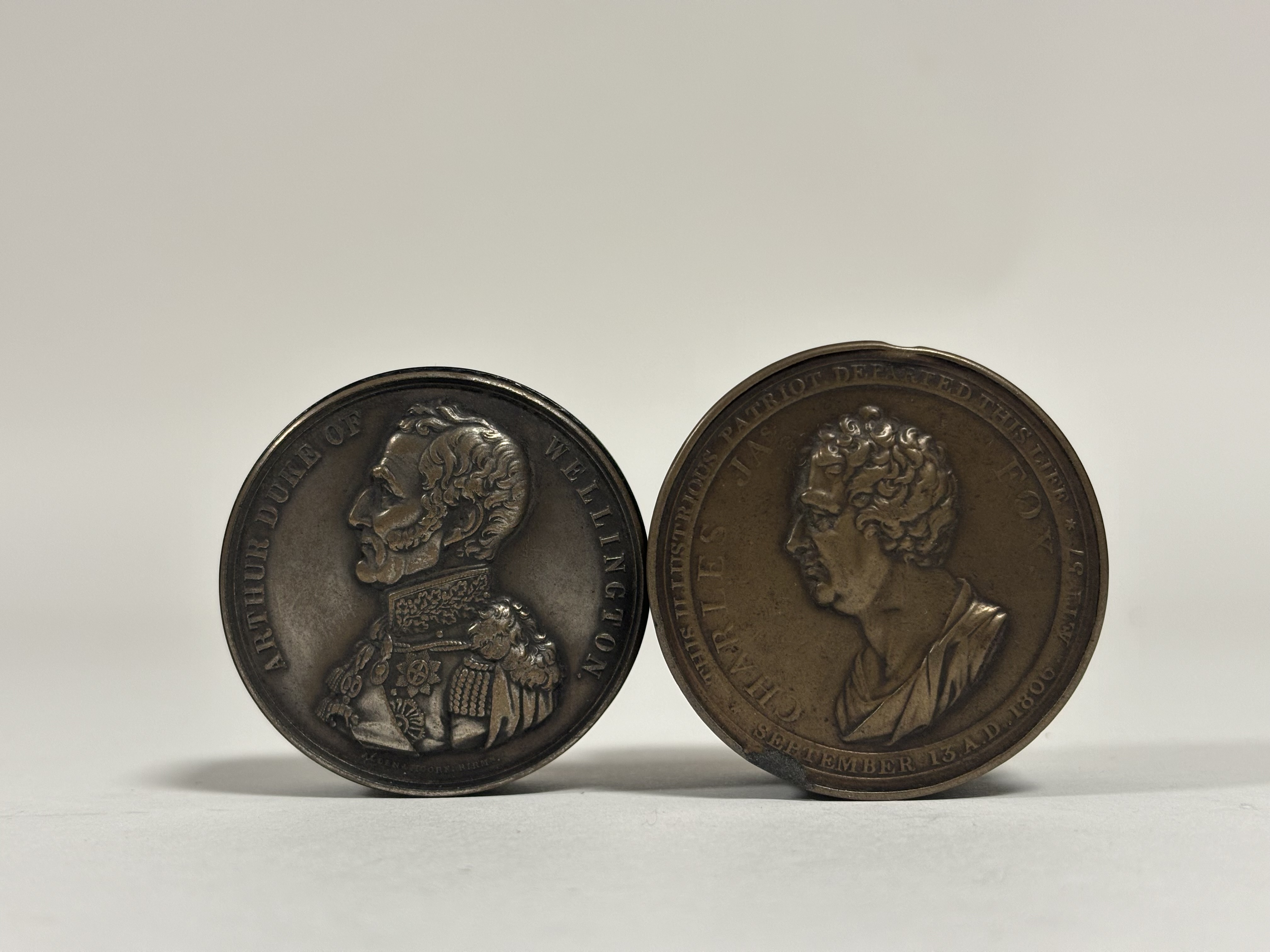 Two 19th century commemorative snuff boxes: a bronzed spelter circular example based on the design