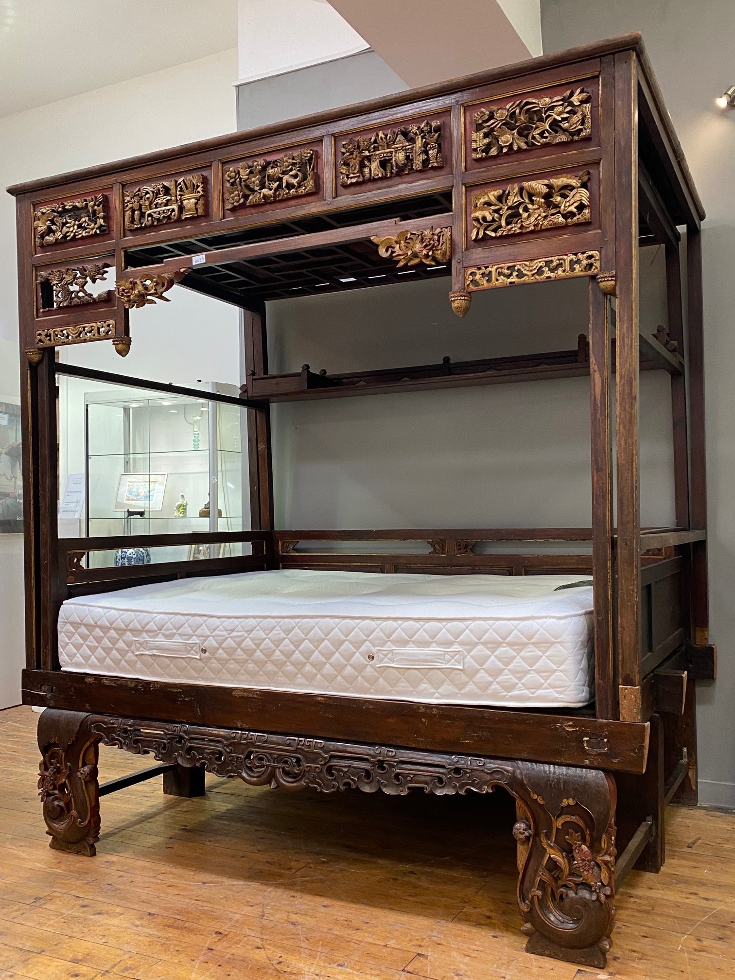 A Chinese parcel gilt opium or canopy bed, circa 1900, with latticed and panelled roof above seven