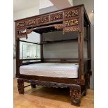 A Chinese parcel gilt opium or canopy bed, circa 1900, with latticed and panelled roof above seven