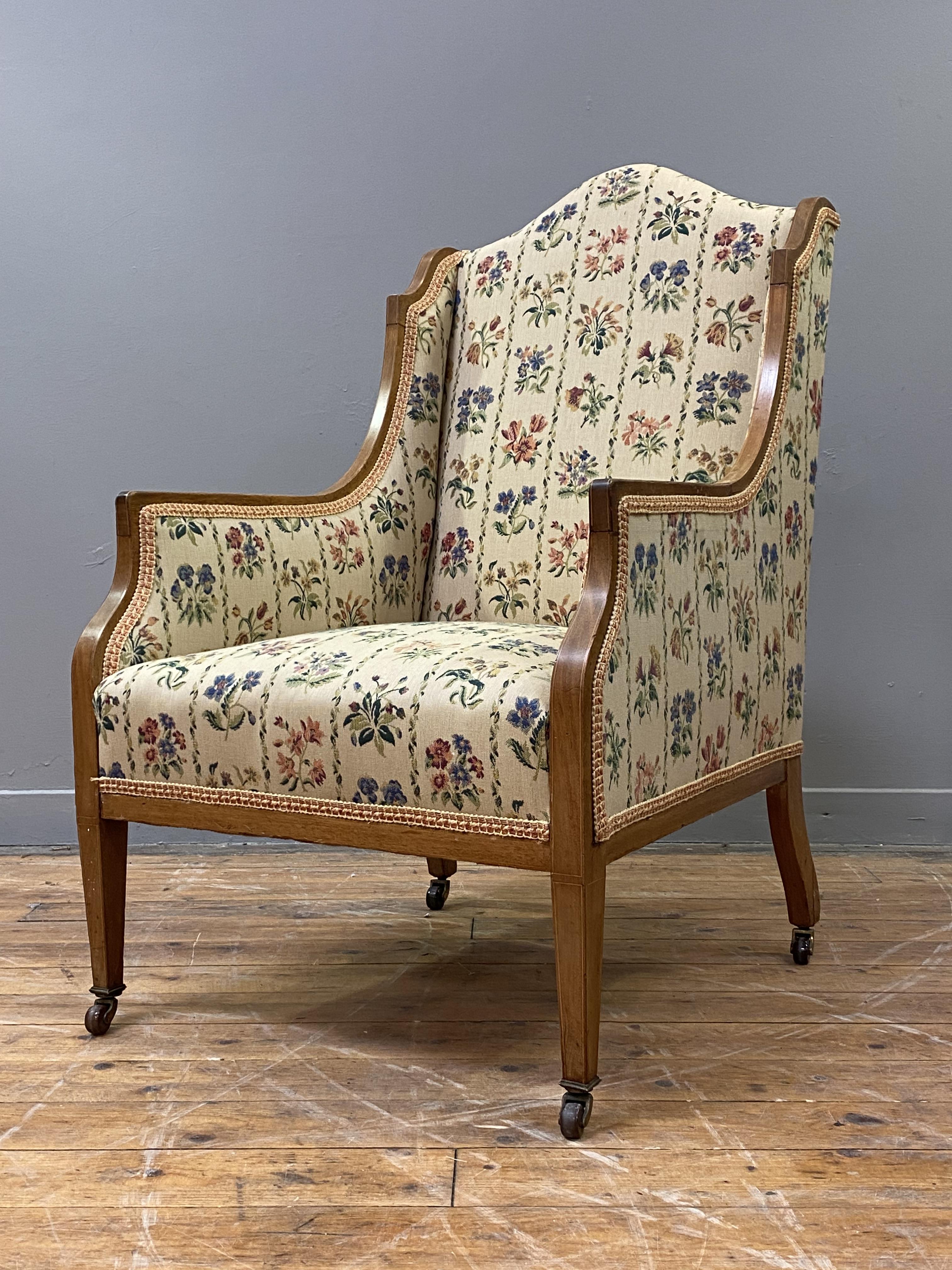 A Edwardian mahogany framed easy chair with upholstered panelled back, and arms, the show frame with